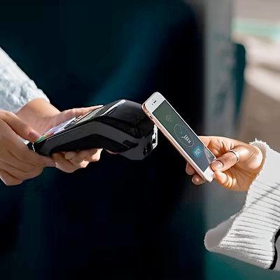 Hands using smartphone and payment terminal
